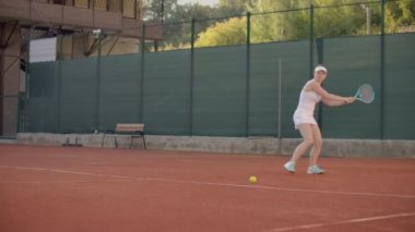 Profesyonel donanımlı kadın tenis raket ile tenis topu sert yenerek. Profesyonel donanımlı kadın tenis raket ile sert tenis topu yenerek.