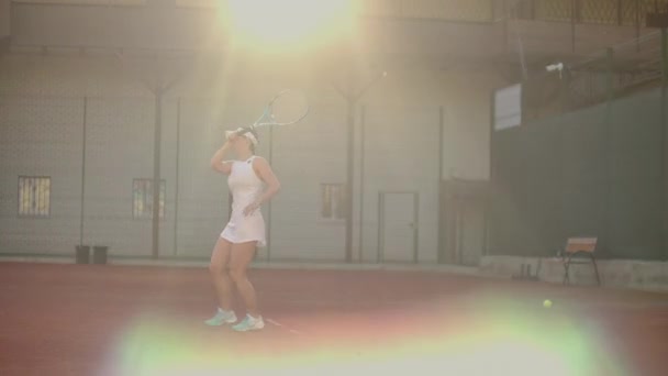 Профессионально оборудованная женщина бьет теннисный мяч теннисной ракеткой. Профессионально оборудованная женщина бьет теннисный мяч теннисной ракеткой . — стоковое видео