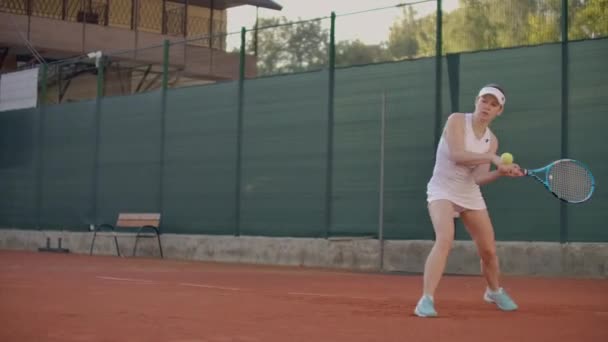 Hermosa jugadora de tenis juega pelotas en la pista de tenis. Jugador de tenis profesional cámara lenta — Vídeos de Stock