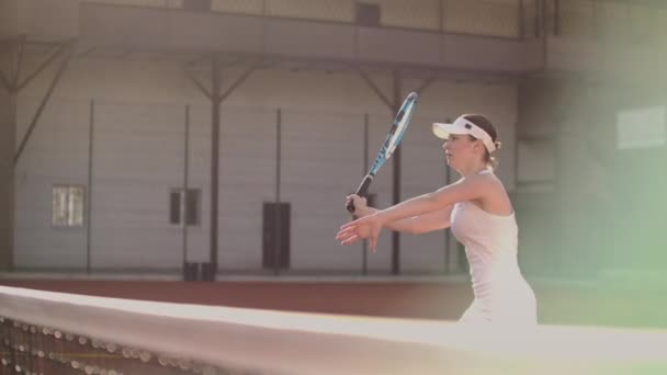 Jugadora de tenis en pista de tenis jugando tenis en cámara lenta con raqueta y al atardecer — Vídeo de stock