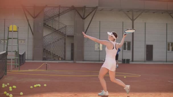 Επαγγελματικά εξοπλισμένη γυναίκα που χτυπά σκληρά την μπάλα του τένις με ρακέτα του τένις. Επαγγελματικά εξοπλισμένη γυναίκα που χτυπά σκληρά την μπάλα του τένις με την ρακέτα του τένις. — Αρχείο Βίντεο