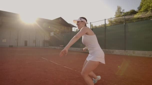 Професійно обладнана жінка жорстко б'є тенісний м'яч з тенісним ракеткою. Професійне обладнане жіноче побиття жорсткий тенісний м'яч з тенісним ракеткою . — стокове відео
