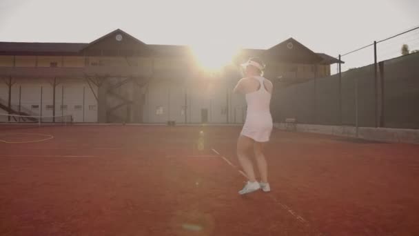网球比赛在阳光明媚的日子在网球场年轻的运动女子打职业网球。网球比赛在阳光明媚的一天在网球场年轻的运动女子玩 — 图库视频影像