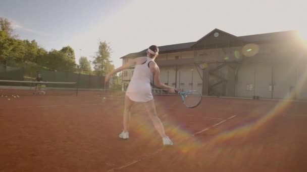 Profesyonel donanımlı kadın tenis raket ile tenis topu sert yenerek. Profesyonel donanımlı kadın tenis raket ile sert tenis topu yenerek. — Stok video