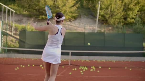 Kortta kadın tenisçi uçan bir topa vurur, açık kortta tenis dinamik bir oyun. — Stok video