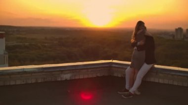 Romantik Tarih çatıda. Gün batımında çatıya çıkan sevgi dolu çiftin.