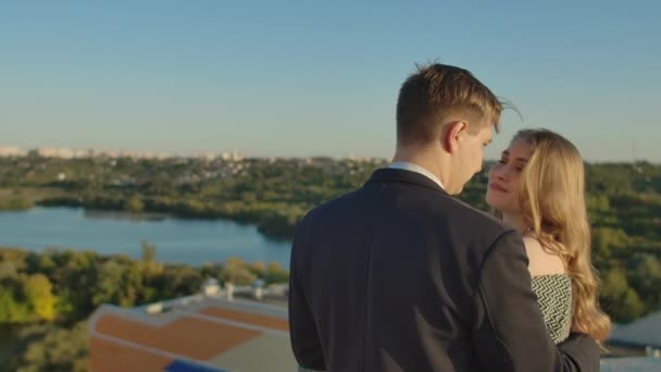 Romantic date on the roof. Loving couple dating on the roof at the sunset. — Stock Video