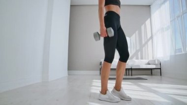 genç fit ve enerjik kadın güneşli bir gün boyunca evde oturma odasında sağlıklı yaşam tarzı için ağırlıkları ile spor egzersiz ve fitness lunge egzersizleri yapıyor.