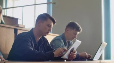 Çok etnik öğrencilerin çalışma Modern sınıfta bir ders dinleme sırasında dizüstü bilgisayarlarda büyük grup. Üniversitesi'nde çalışma parlak gençler