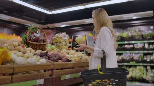 Genç ve güzel kadın Pazar sebze satın alma. — Stok video