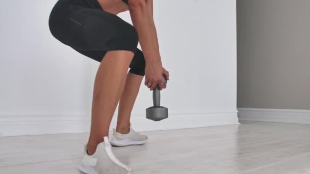 Młoda kobieta fitness robi squat z hantlami w rękach — Wideo stockowe