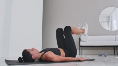 Kuvvet eğitim vücut ağırlığı egzersiz kadın atlet Flutter Kicks yapıyor. Avrupalı kadın yetişkin evinde evinde abs kasları egzersiz Bacak Yükseltir ile zemin egzersizleri yapıyor.