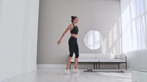 Fitness kadın evde burpee egzersiz yapıyor. Genç kadının orta çekim push up ve yavaş çekim egzersiz atlama yapıyor. Spor konsepti. — Stok video