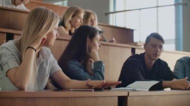 Dersten önce bir konferans salonunda oturan neşeli mutlu öğrenciler grubu. Dersten önce bir derssalonunda oturan neşeli öğrencilerden oluşan bir grup