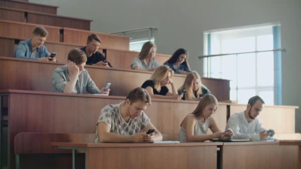 Los estudiantes chatean en línea en un aula universitaria. Los introvertidos y el miedo a las personas — Vídeos de Stock