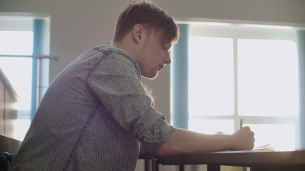 The camera moves through the audience where the students write a lecture on laptops and notebooks for professors in a large classroom of a university or college — Stock Video