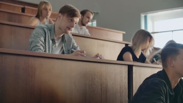 Les jeunes étudiants qui réussissent dans une grande classe universitaire écoutent et enregistrent une conférence, une vraie conférence à l'université 