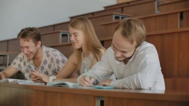 Dersten önce bir konferans salonunda oturan neşeli mutlu öğrenciler grubu. Dersten önce bir derssalonunda oturan neşeli öğrencilerden oluşan bir grup