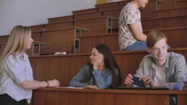 Dersten önce bir konferans salonunda oturan neşeli mutlu öğrenciler grubu. Dersten önce bir derssalonunda oturan neşeli öğrencilerden oluşan bir grup