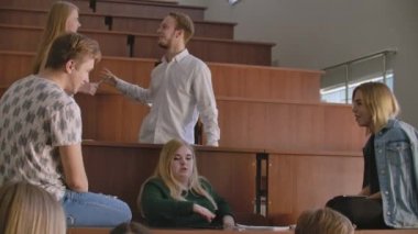 Neşeli mutlu öğrencilerin ders önce bir konferans salonunda oturan Grup.