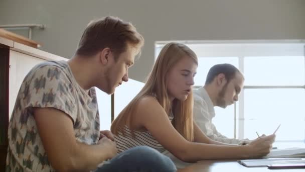 Gruppen av glada glada studenter sitter i en föreläsningssal innan lektionen. Gruppen av glada studenter som sitter i en föreläsningssal före lektionen — Stockvideo