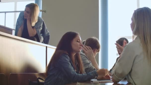 レッスン前に講演会場で座っている陽気な幸せな学生のグループ. — ストック動画