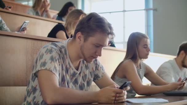 Los estudiantes chatean en línea en un aula universitaria. Los introvertidos y el miedo a las personas — Vídeo de stock