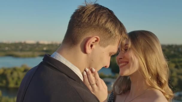 Un homme et une femme s'embrassent sur un toit au coucher du soleil — Video