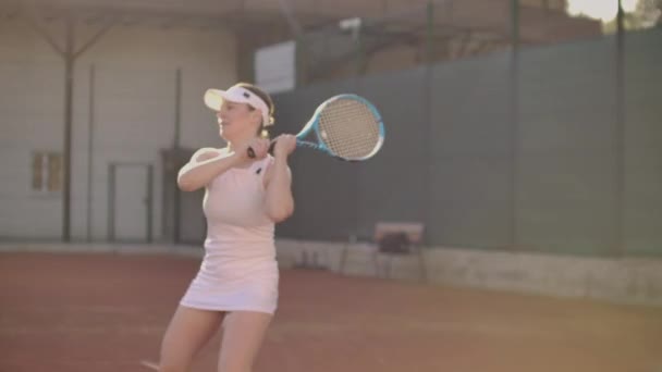 Jugador de tenis alcanzando a golpear la pelota. Jugadora de tenis llegando a golpear la pelota de tenis en la cancha . — Vídeos de Stock