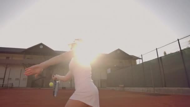 Cheerful athlete waiting for tennis ball. Skillful female tennis player is preparing to beat a ball. She is holding a racket and posing. Woman is standing on tennis. — Stock Video