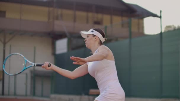 Jugadora de tenis que practica golpear la pelota con el entrenador, golpeando la pelota con una raqueta en cámara lenta. Entrenamiento profesional de jugador de tenis — Vídeo de stock