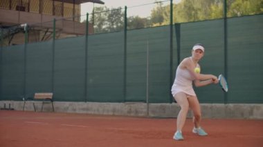 Yavaş hareket : Öğleden sonra kortta oynayan profesyonel tenisçi kadın.