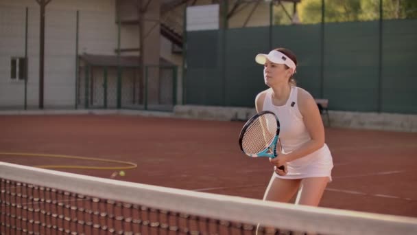 Tenisz játékos elérése a hit Ball. Női teniszező eléri a hit a teniszlabda a bíróságon. — Stock videók