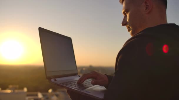 Hipster hombre con un portátil en el borde del techo. Freelancer trabajando. Internet móvil inalámbrico. Trabaja en Internet — Vídeo de stock