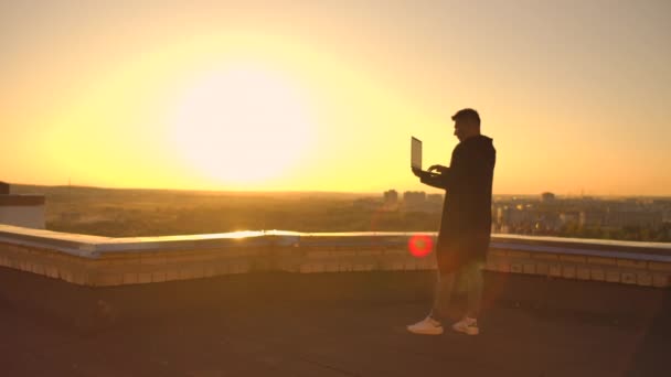 Hacker using laptop on rooftop with city view and forex chart. Hacking and stats concept — Stock Video