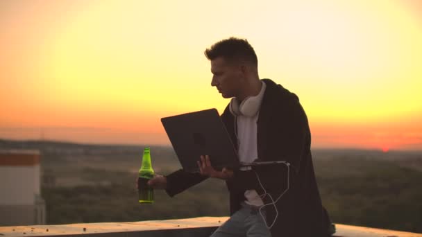 Hipster-Mann mit Laptop auf dem Dach. Freiberufler bei der Arbeit. Mobiles drahtloses Internet. Er arbeitet im Internet — Stockvideo