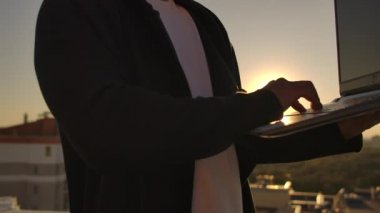 Hacker şehir görünümü ve forex grafik ile çatı üzerinde dizüstü bilgisayar kullanarak. Hacking ve istatistik kavramı