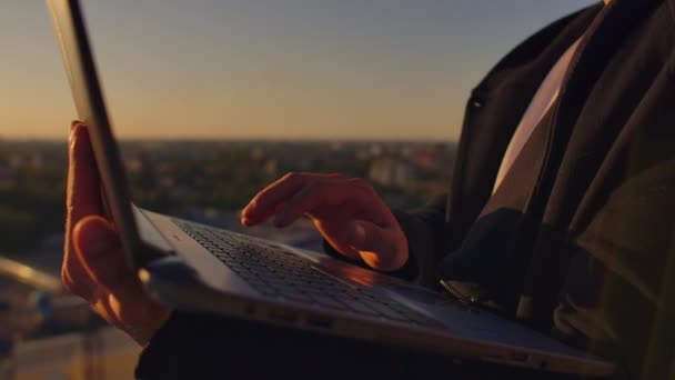 Hacker mit Laptop auf dem Dach mit Blick auf die Stadt und Devisenkarte. Hacking und Statistik-Konzept — Stockvideo