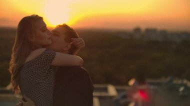 Aşıklar gün batımında çatıda göz göze gelirler. Çatıda romantik bir çift