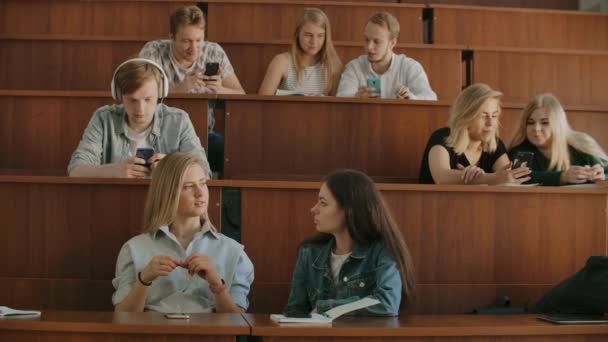 Un grand groupe d'étudiants pendant la pause communiquent entre eux dans la salle de classe. Grande classe — Video