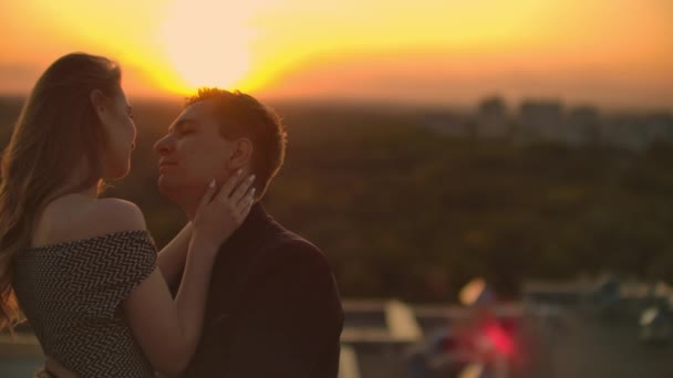 恋人たちは日没時に屋根の上で互いに目を見る。屋根の上のロマンチックなカップル — ストック動画