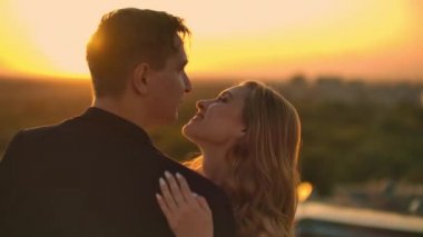 Çatıda dans eden bir adamla öpüşen bir kız.