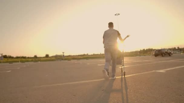 Lens flare: Allegro coppia uomo e donna al tramonto cavalcare carrelli supermercato al rallentatore — Video Stock