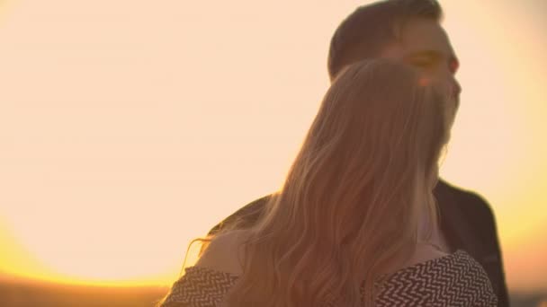 Dua kekasih menari bersama di atap saat matahari terbenam di bawah sinar matahari — Stok Video