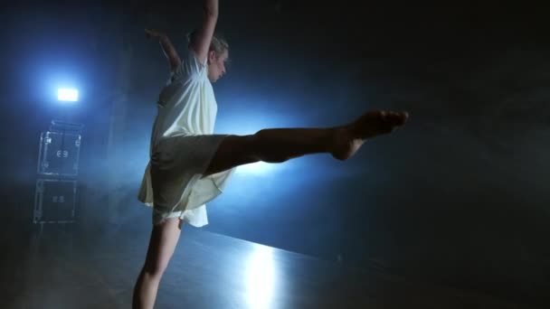 Modern ballet dancing woman barefoot doing spins and pirouettes and dance steps standing on stage in smoke in slow motion. Performance on stage — Stock Video