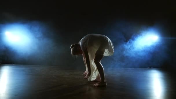Σύγχρονη χορεύτρια μπαλέτου ξυπόλητη ξαπλωμένη στο πάτωμα κάνοντας περιστροφές και πιρουέτες και τούμπες. — Αρχείο Βίντεο
