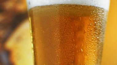 Su damlalı bir bardakta soğuk light bira. Craft Birası yakın çekim. Döndürme 360 derece