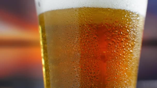 Close-up slow motion: cold Beer in a glass large drops and bubbles in the beer. — Stock Video
