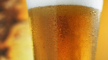 Su damlalı bir bardakta soğuk light bira. El yapımı birayı kapat..