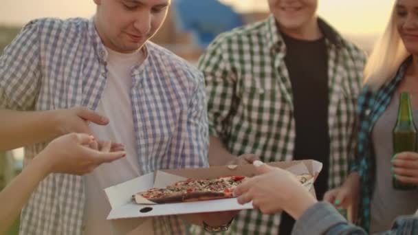 Uma empresa de seis jovens analisa pedaços de pizza quente juntos — Vídeo de Stock